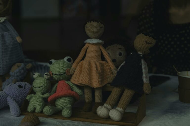 A delightful set of handmade knitted dolls and stuffed animals on display, showcasing intricate craftsmanship.